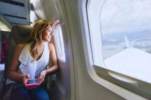 Donna che osserva paesaggio dall'oblò dell'aereo