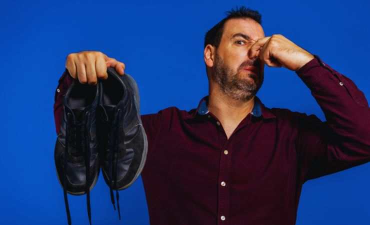 uomo si tiene il naso per l'odore delle scarpe