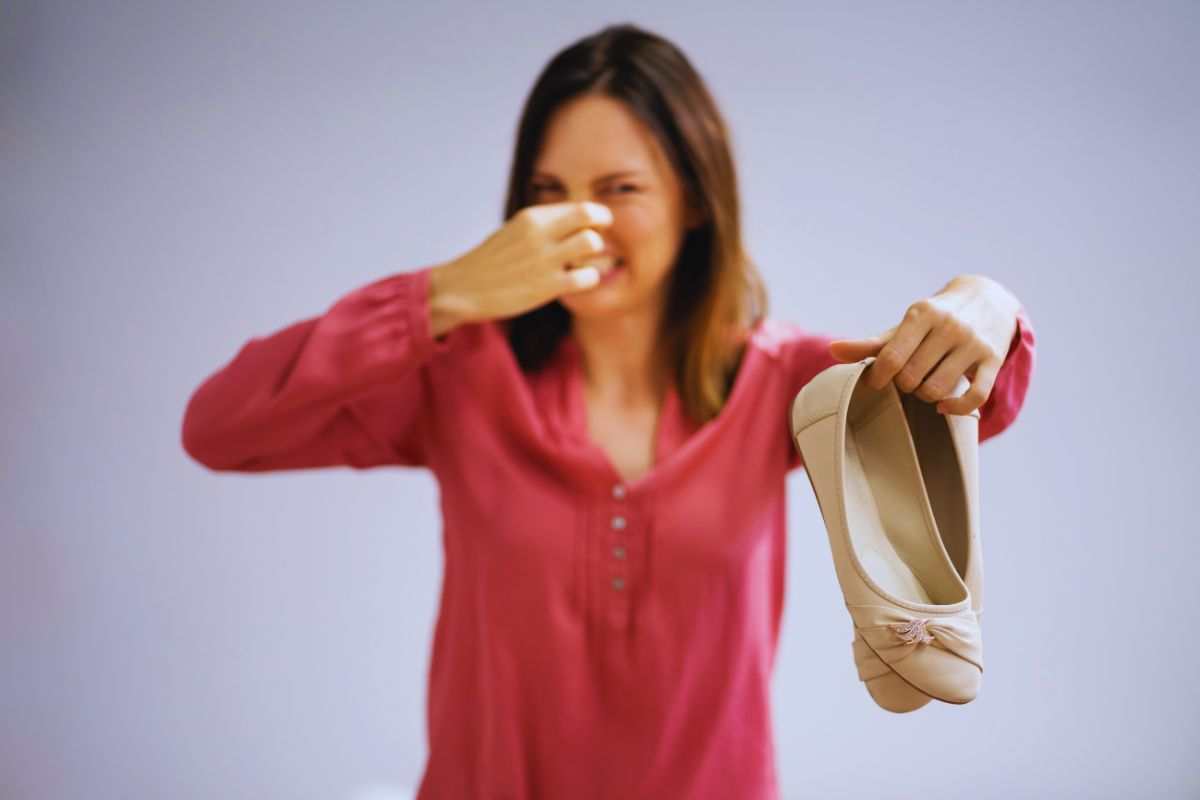 donna si tiene il naso per l'odore delle scarpe