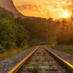 binari treno e tramonto all'orizzonte
